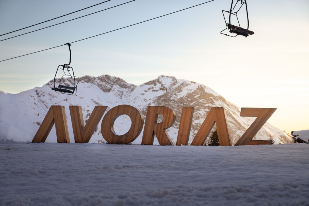 big letters spelling out AVORIAZ with the ski lifts above and mountains in the background